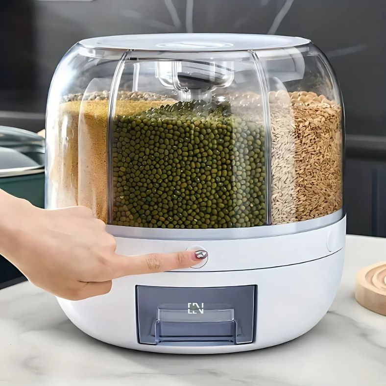 Dispello™ van Inicala.nl in gebruik – een vinger drukt op de doseerknop van de 6-in-1 voedselcontainer met transparante vakken, voor snel en nauwkeurig afmeten.