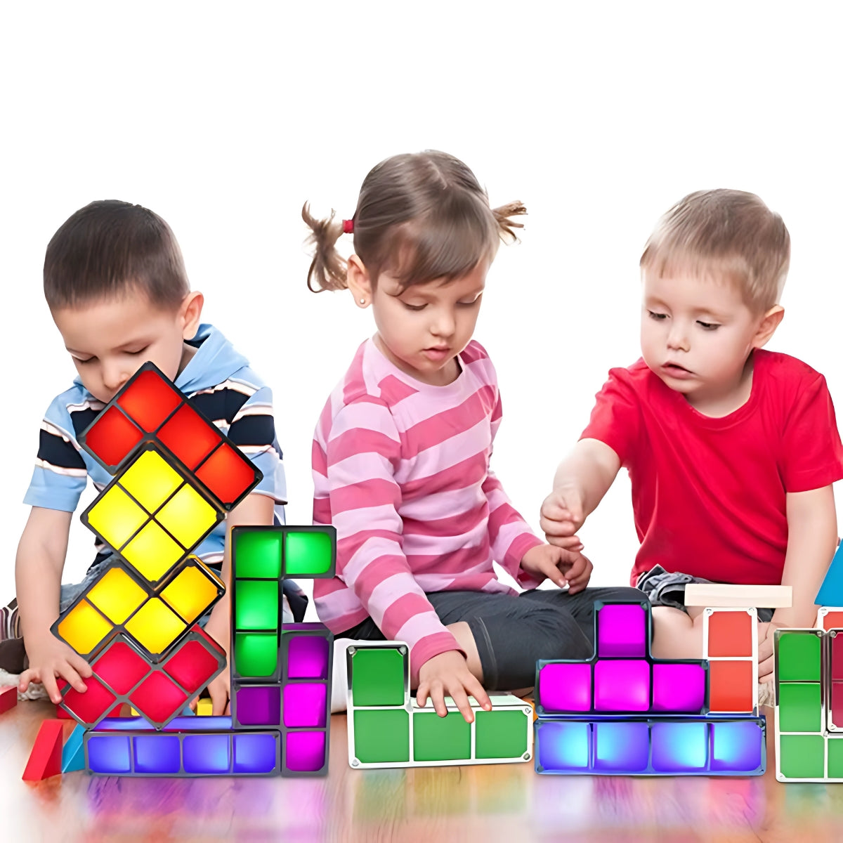 Drie kinderen bouwen kleurrijke TetraGlow™-creaties met verlichte blokken in groen, rood, geel, paars en blauw. Ze stapelen en spelen samen, wat zorgt voor een speelse en creatieve sfeer. Perfect voor fantasierijk spel en samenwerking. inicala
