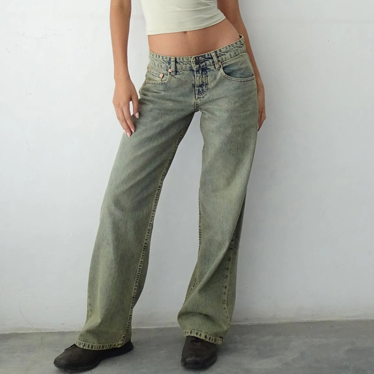 Een close-up van de Amara Retro-Low Jeans in een olijfkleurige vintage wassing, perfect voor een relaxte maar stijlvolle look. Verkrijgbaar op Inicala.nl!