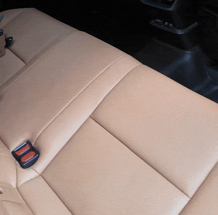 HangEase™ Organizer van Inicala.nl wordt snel aan de hoofdsteun van een beige autostoel bevestigd; luxe dubbele haak om eenvoudig tassen en accessoires netjes in de auto op te hangen.