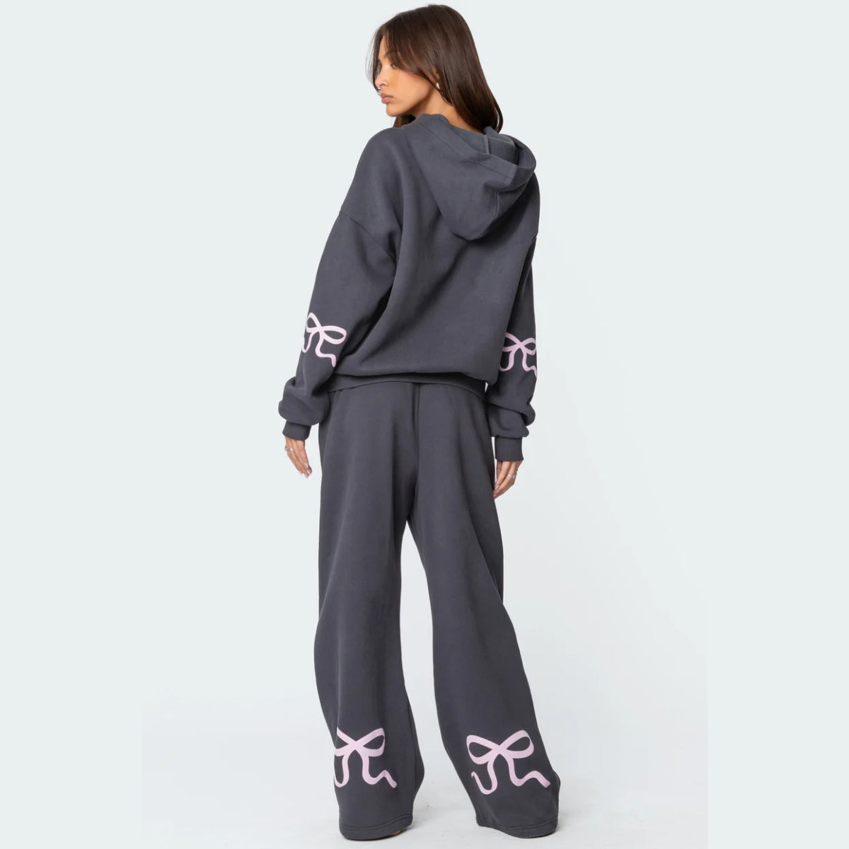 Luna Ribbon Tracksuit - Elegantie in Comfort Donkergrijze broek met wijde pijpen, versierd met subtiele roze strikdetails. Perfect voor een moeiteloze, stijlvolle look. Shop nu op Inicala.nl en ervaar ultiem comfort met ee