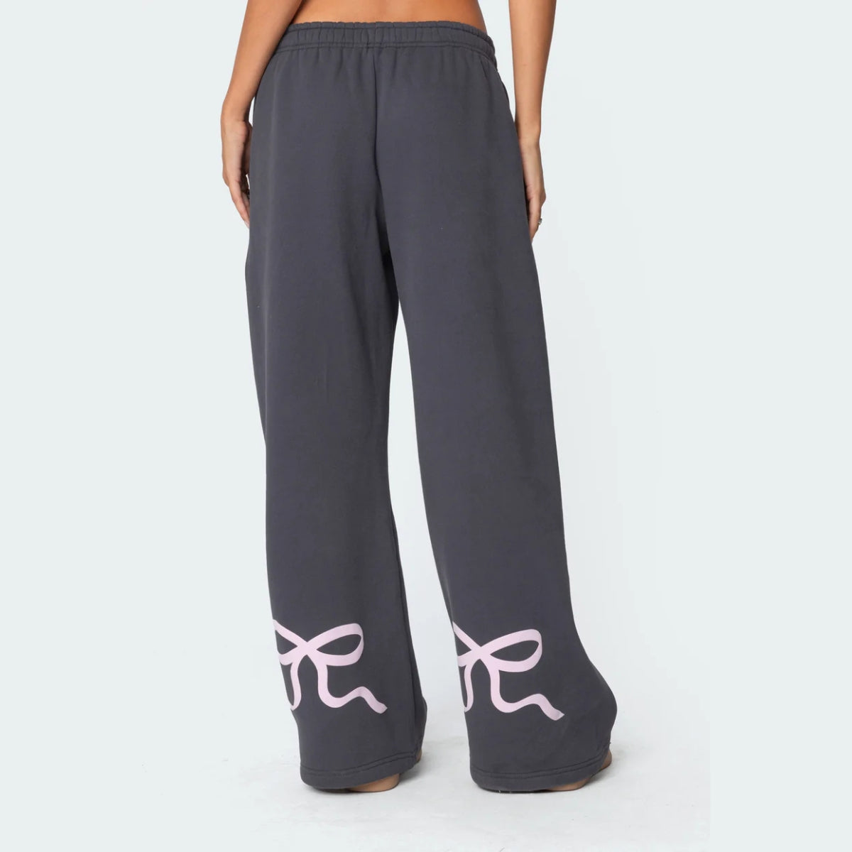 Luna Ribbon Tracksuit - Elegantie in Comfort Donkergrijze broek met wijde pijpen, versierd met subtiele roze strikdetails. Perfect voor een moeiteloze, stijlvolle look. Shop nu op Inicala.nl en ervaar ultiem comfort met