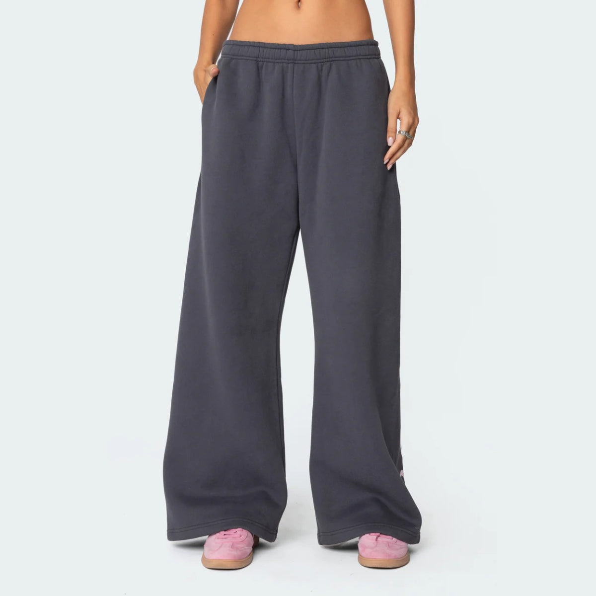 Luna Ribbon Tracksuit - Elegantie in Comfort Donkergrijze comfortabele broek met een wijde pasvorm en elastische taille. Voorzien van delicate roze strikaccenten aan de zoom. Perfect voor een stijlvolle en relaxte look. Sh