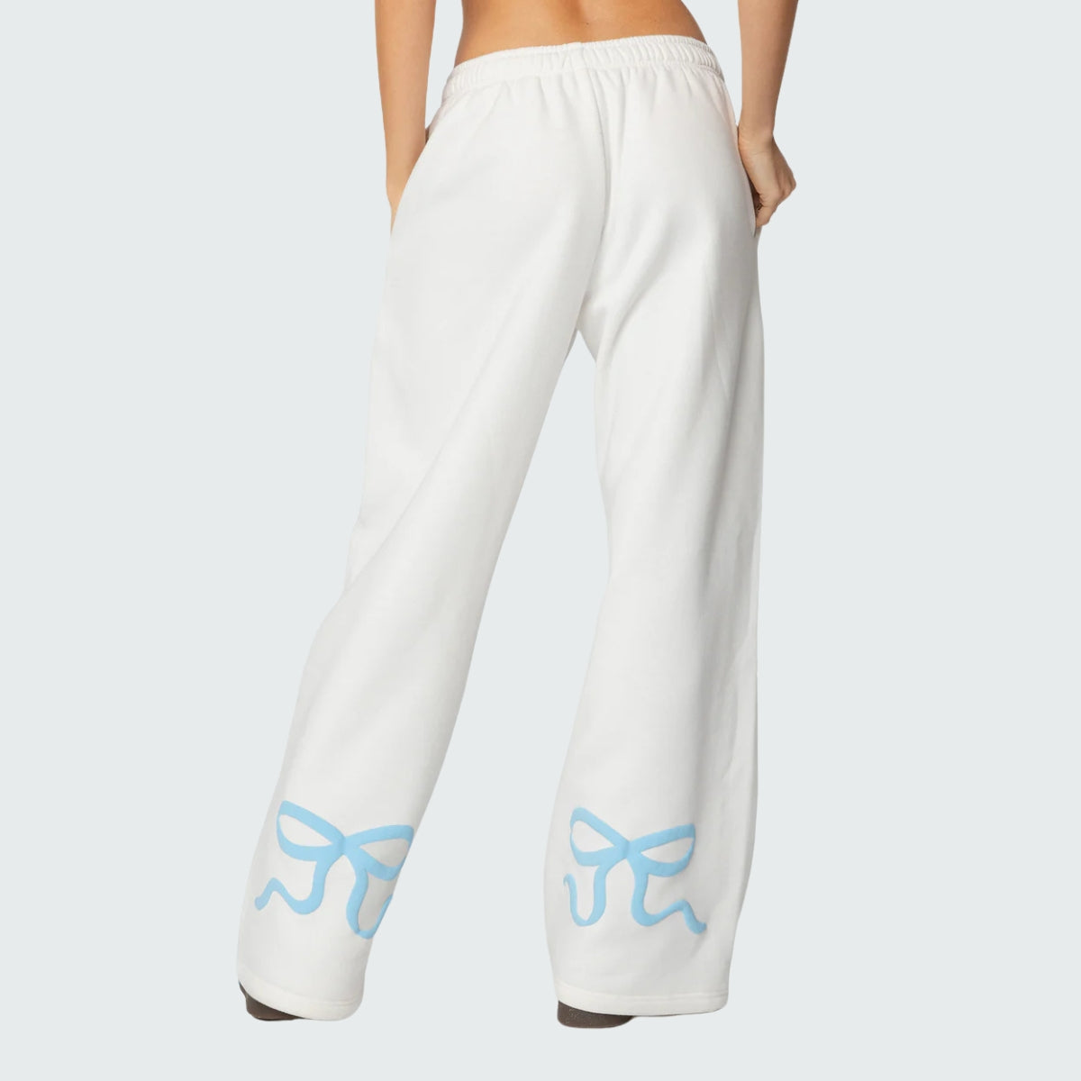 Luna Ribbon Tracksuit - Elegantie in Comfort Witte broek met losse pasvorm en elastische taille, gedecoreerd met speelse blauwe strikaccenten. Perfect voor casual chic. Shop exclusief via Inicala.nl.