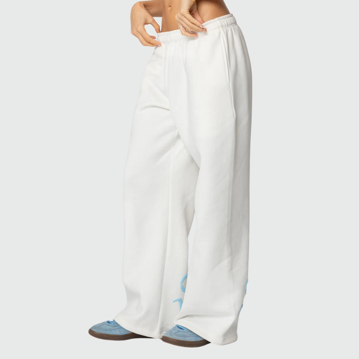 Luna Ribbon Tracksuit - Elegantie in Comfort Witte wijde broek met blauwe strikdetails, ontworpen voor ultiem comfort en stijl. Beschikbaar via Inicala.nl.