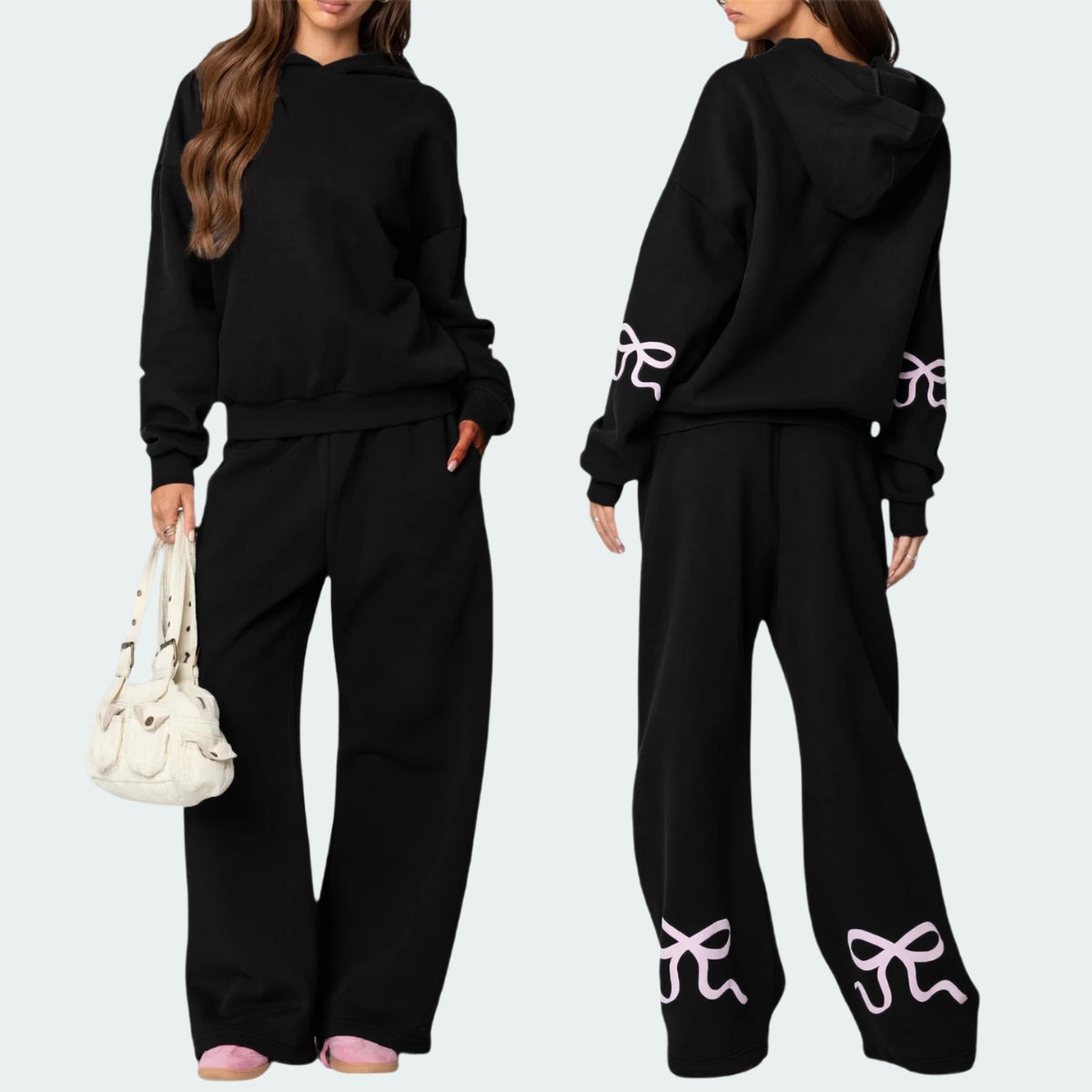 Luna Ribbon Tracksuit - Elegantie in Comfort Stijlvolle zwarte tracksuit met roze strikdetails op mouwen en broekspijpen. Perfect voor een casual maar verfijnde look. Exclusie