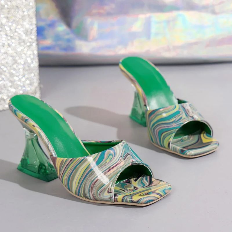 Marbellé™ – Waar Kunst en Mode Samenkomen van Inicala.nl. Groen-blauwe hakslippers met swirlpatroon, transparante hak en comfortabele zool. Stijlvol en uniek zomerdesign.