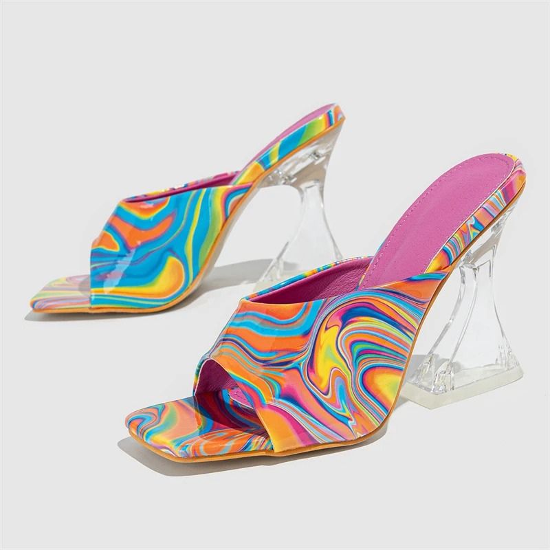 Marbellé™ – Waar Kunst en Mode Samenkomen van Inicala.nl. Multicolor hakslippers met transparante hak, opvallend swirl-patroon en roze voetbed. Trendy en uniek zomers design.