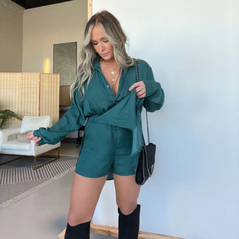 Model draagt de Levana™ – Satijnen Blousejurk in smaragdgroen van Inicala.nl; een luchtige, glanzende jurk met wikkel-look en elegante pasvorm – perfect voor stijlvolle dagen en avonden.