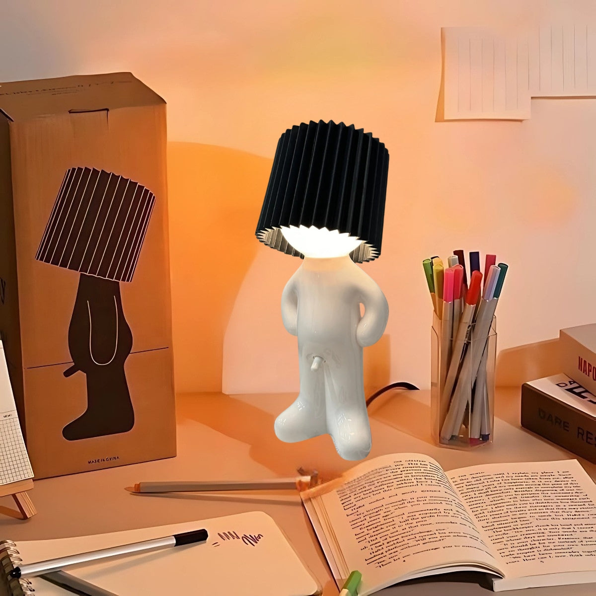 Naughty Glow Guy™ Grappig, brutaal, met een grenzeloze glimlach! Een ondeugend lampje met een stijlvolle zwarte kap, perfect voor een speelse touch op je bureau of nachtkastje. Creëer sfeer én humor! Bezoek Inicala.nl voor meer informatie.