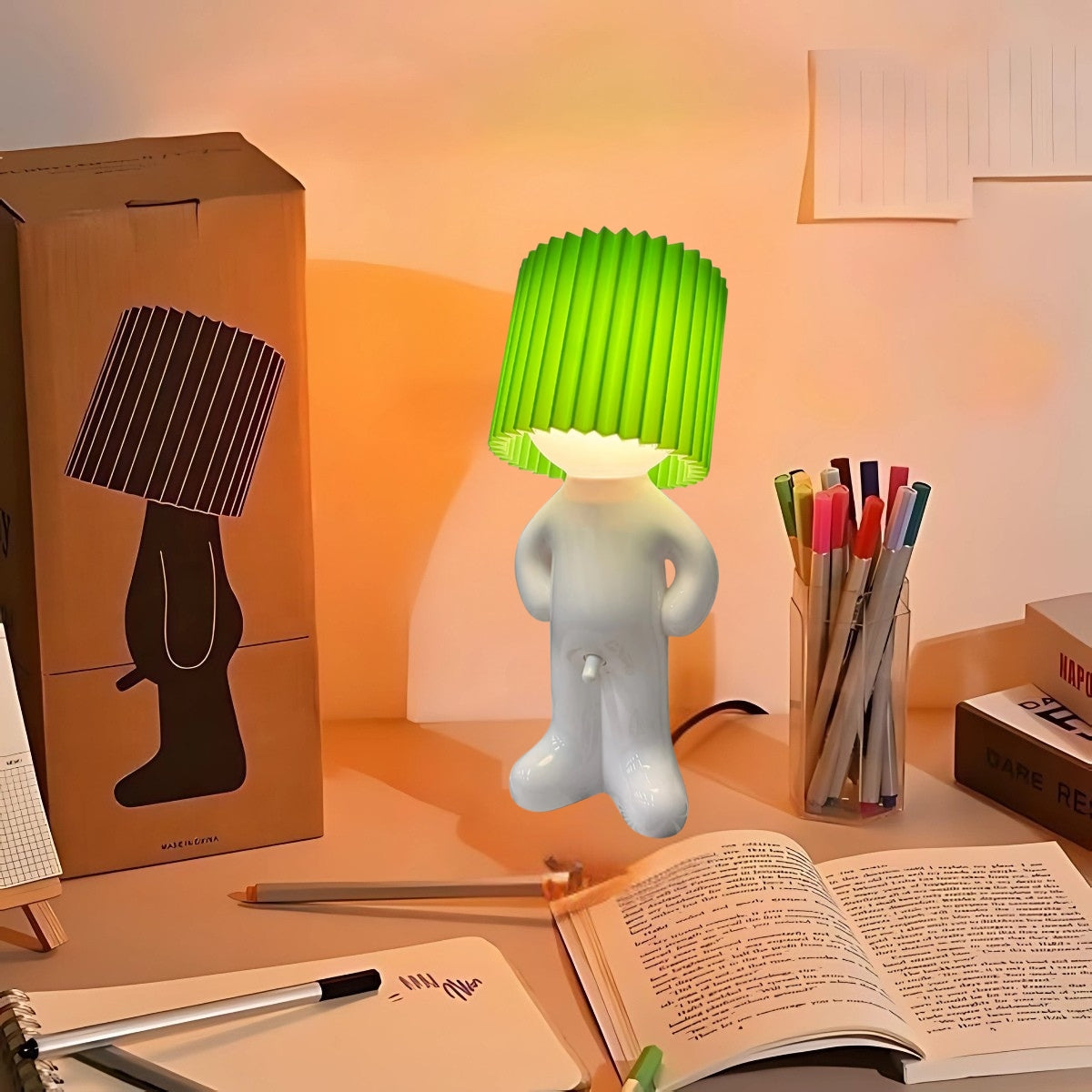 Naughty Glow Guy™ Grappig, brutaal, met een grenzeloze glimlach! Een speelse lamp met een opvallende groene kap, perfect voor een vleugje humor en licht op je bureau of nachtkastje. Ontdek meer op Inicala.nl!