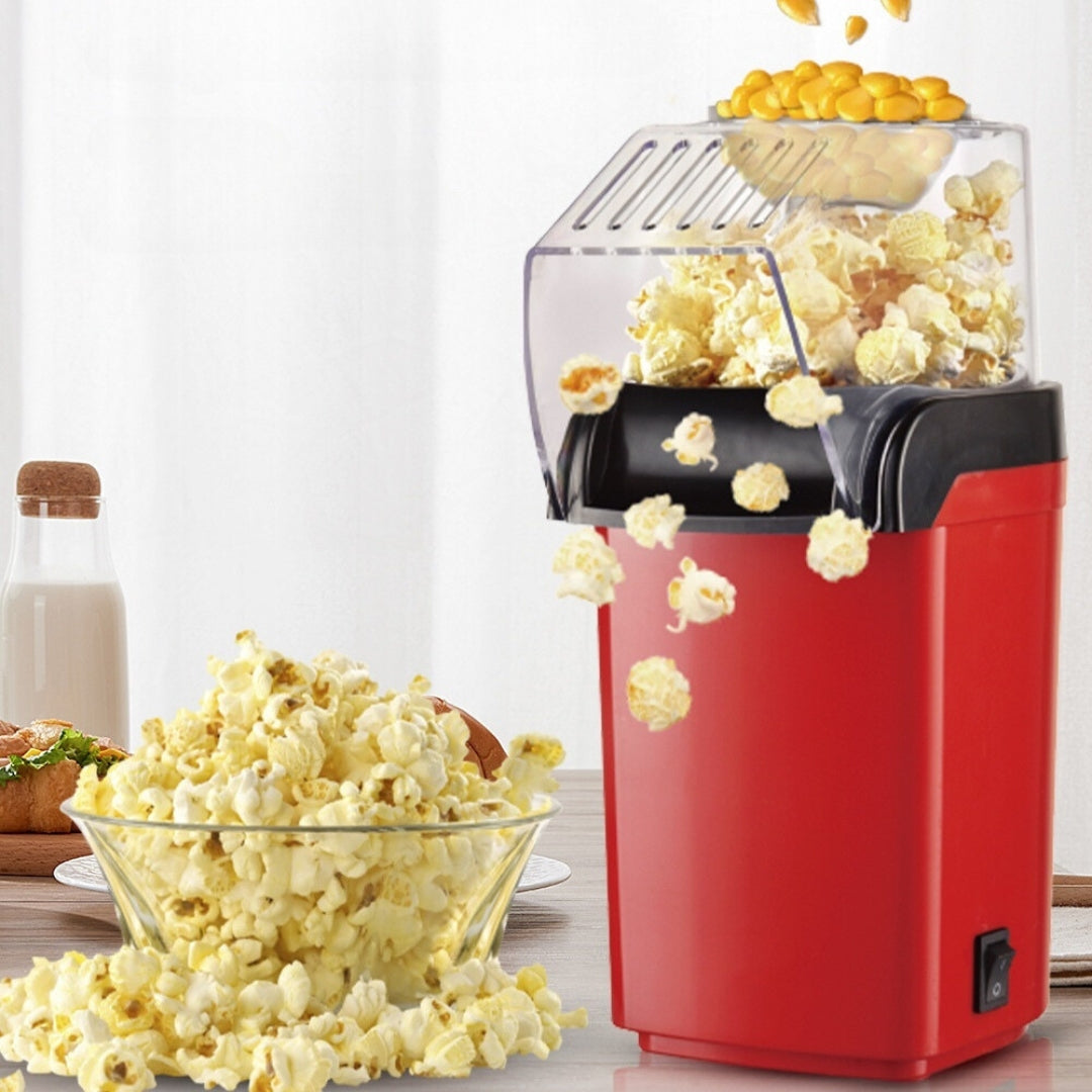 Rode PopCrisp™ popcornmaker die verse popcorn in een glazen schaal laat vallen. Gezond, vetvrij en ideaal voor een snelle snack in een moderne keuken. inicala.nl