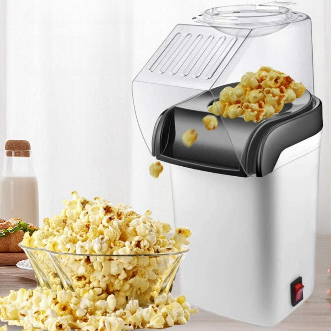 Witte PopCrisp™ popcornmaker die verse, luchtige popcorn in een glazen schaal laat vallen. Gezond, vetvrij snacken in een modern keukenontwerp. inicala.nl