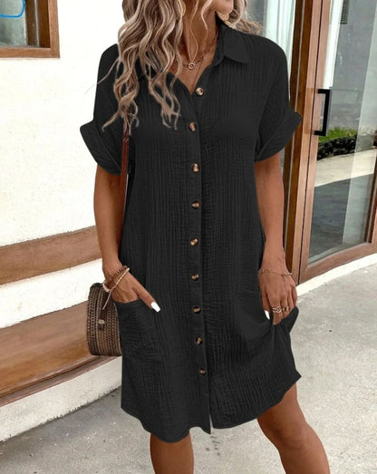 AerisBelle™ Zomerjurk in zwart van Inicala.nl – stijlvolle, luchtige jurk met knoopsluiting en zakken, ideaal voor een moeiteloos elegante zomerdag.