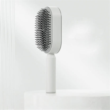 De SwiftBrush™ Zelfreinigende Massage Haarborstel in een elegant wit ontwerp, biedt een eenvoudige en hygiënische manier om je haar te verzorgen met één druk op de knop.