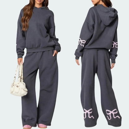 Luna Ribbon Tracksuit - Elegantie in Comfort Een stijlvolle en comfortabele tracksuit met speelse strikdetails op de mouwen en broek. Ideaal voor ontspannen dagen en casual ui