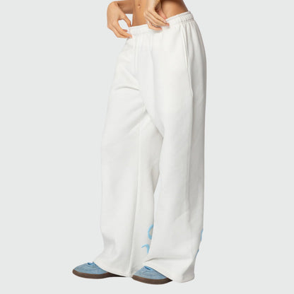 Luna Ribbon Tracksuit - Elegantie in Comfort Witte wijde broek met blauwe strikdetails, ontworpen voor ultiem comfort en stijl. Beschikbaar via Inicala.nl.