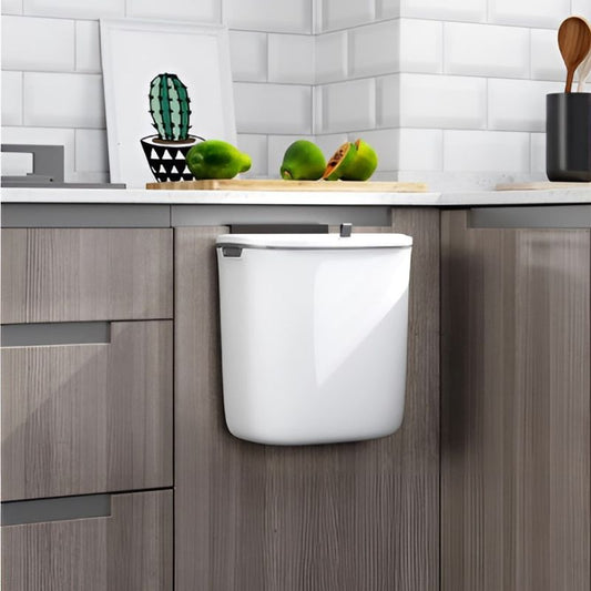 Deze afvalbak met een strak wit design hangt netjes aan een keukenkastje. Hij is compact, stijlvol en maakt afval opruimen eenvoudig. Ideaal voor een georganiseerde, moderne keuken.