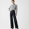 Model draagt de Riviera Flare™ jeans in donker denim van Inicala.nl – een elegante high-waist jeans met rechte, wijde pijpen en gouden knoopdetails, ideaal voor een moderne look met Franse allure.