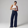 Model draagt de Riviera Flare™ jeans in donker denim van Inicala.nl – een flatterende high-waist broek met wijde pijpen, ideaal voor een krachtige, stijlvolle en comfortabele look.