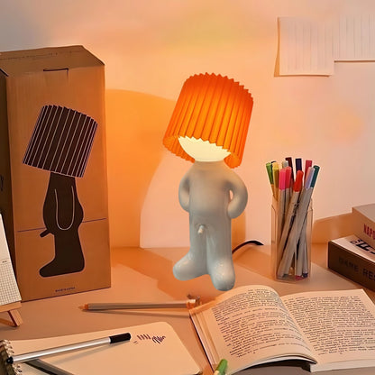 Naughty Glow Guy™  Grappig, brutaal, met een grenzeloze glimlach! Deze speelse lamp met een oranje kap voegt humor en gezelligheid toe aan elke ruimte. Perfect voor je bureau of nachtkastje. Ontdek meer op Inicala.nl!