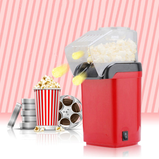 Rode PopCrisp™ popcornmaker met transparante deksel, hete luchtstralen die popcorn naar buiten voeren, en een filmachtige setting met een popcornbeker en filmrollen. inicala.nl