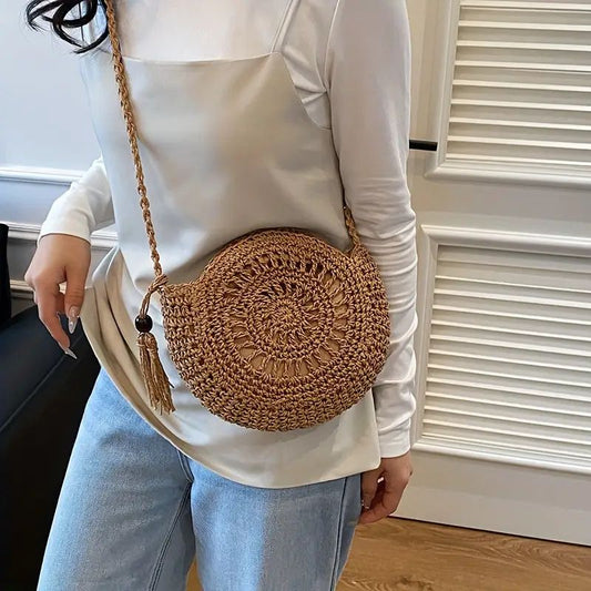 SolaraBoho™ – Ronde handgemaakte gevlochten crossbody tas in bruin, gedragen door een vrouw. Inicala.nl, ideaal als trendy accessoire voor elke casual look.