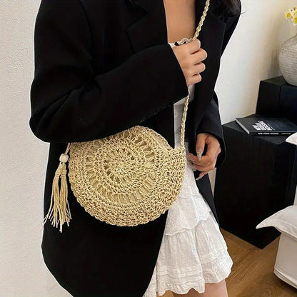 SolaraBoho™ – Ronde handgemaakte gevlochten crossbody tas in naturel, gedragen door een vrouw met witte jurk en zwarte blazer. Inicala.nl, stijlvol boho accessoire.