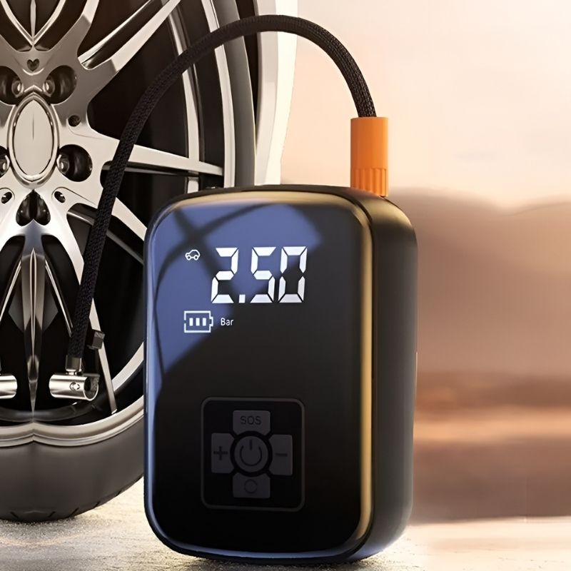 De AirPump™ naast een autoband, klaar voor gebruik, met een digitaal display van 2,50 bar aangegeven. Het compacte, moderne ontwerp maakt het ideaal voor snelle en krachtige oppompen van banden. Perfect voor onderweg of thuis.